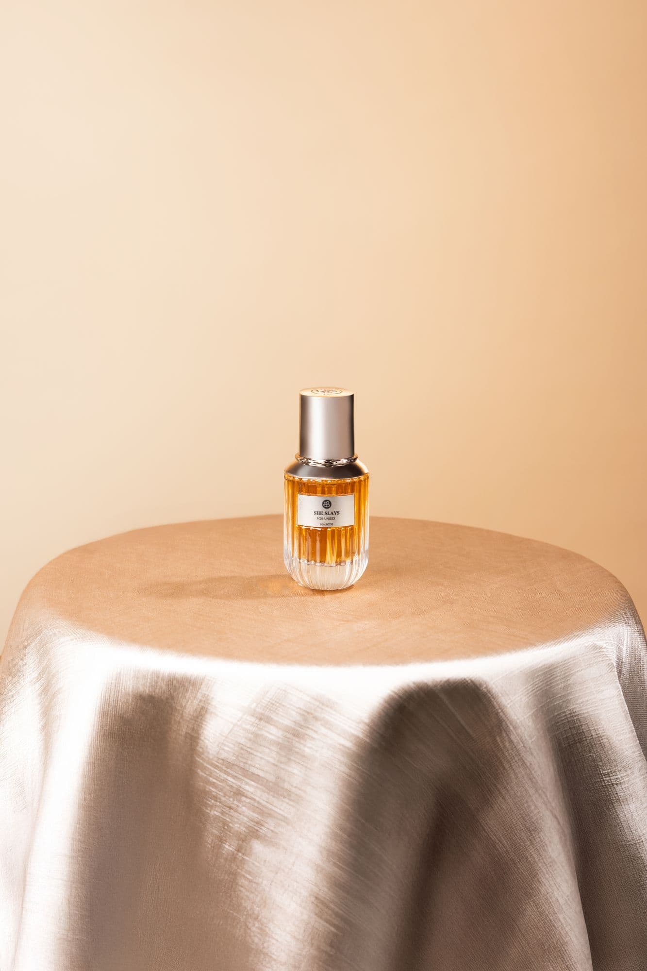 A single Beauboss perfume bottle on a draped satin table